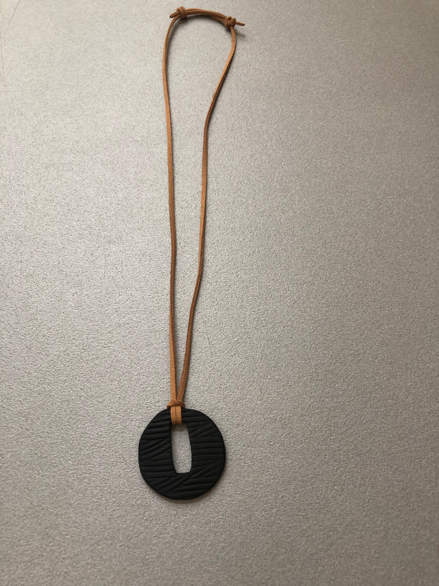 Texture materica a rilievo della collana Segno Nero in porcellana nera opaca, lavorata artigianalmente