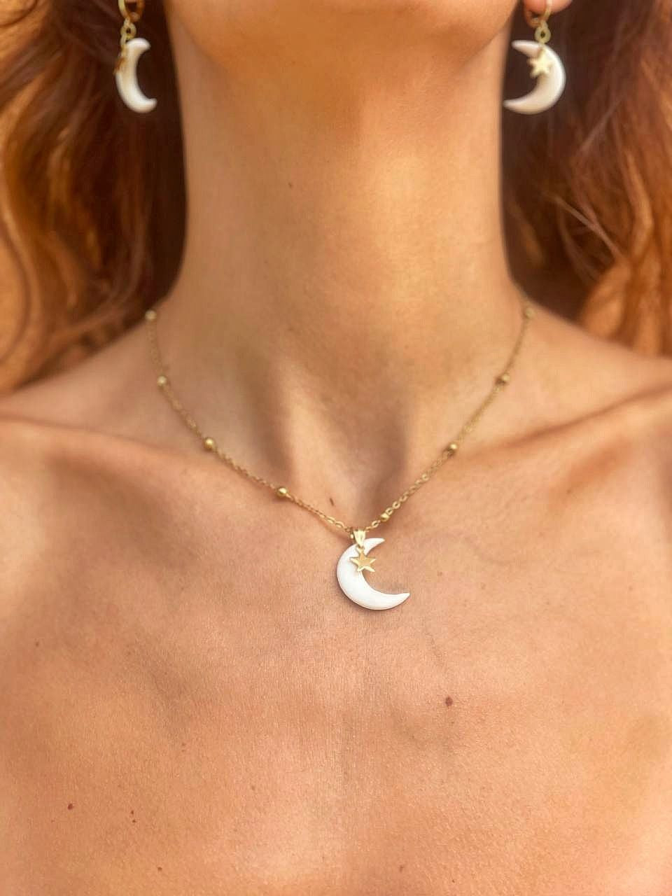 Set collana e orecchini Myra Lab La Luna in porcellana fredda bianca con stellina dorata, realizzati da persone cieche e ipovedenti, indossati da donna