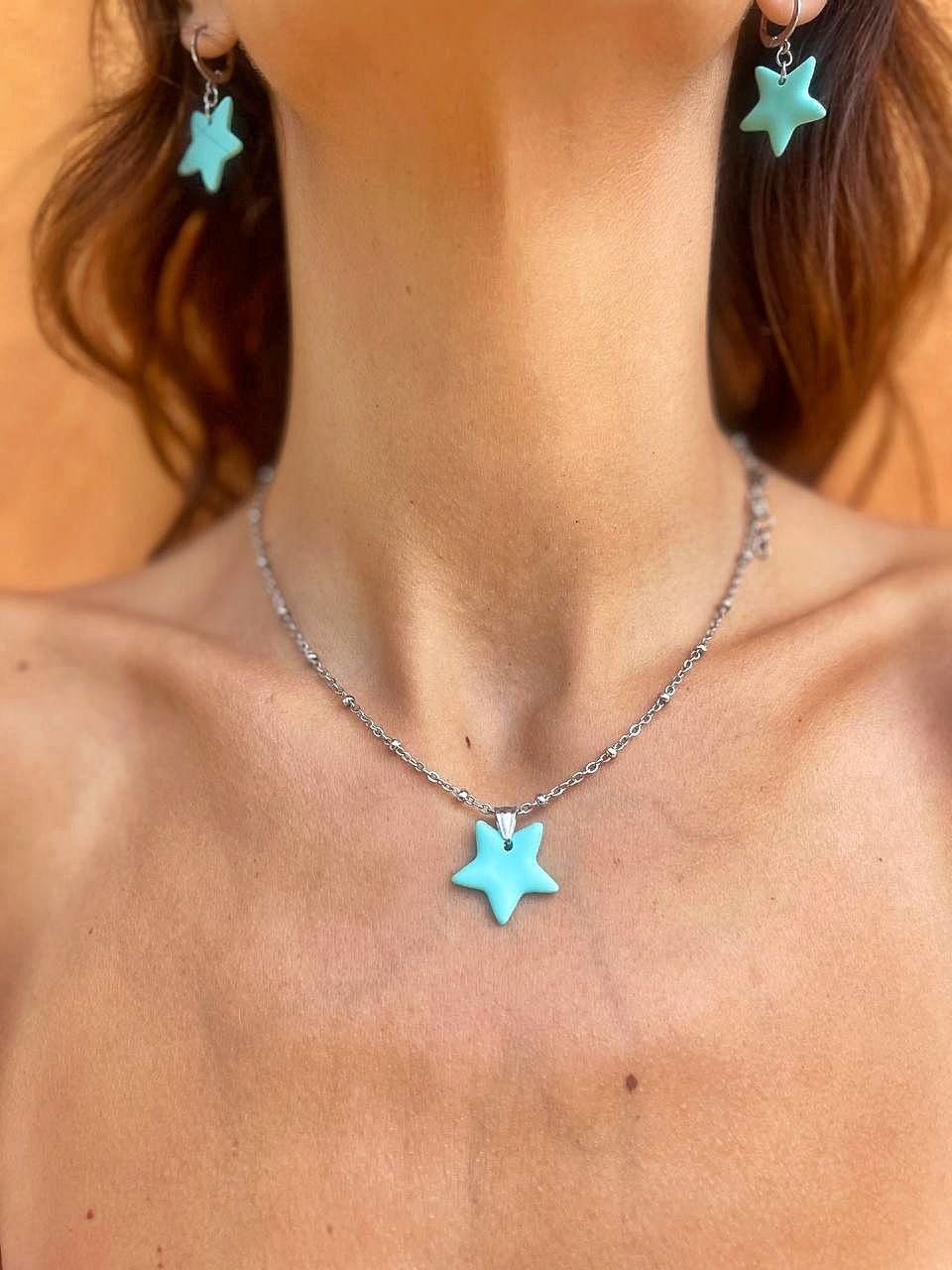 Orecchini e collana artigianali inclusivi Myra Lab a forma di stella marina verde acqua, creati da persone cieche e ipovedenti, indossati da donna in primo piano