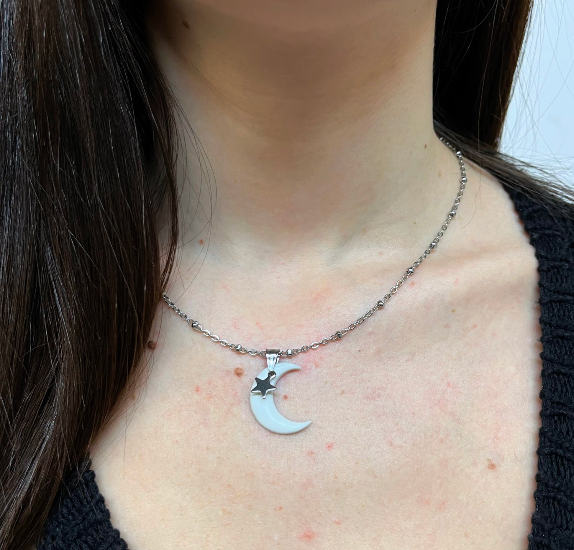Ciondolo artigianale a forma di luna in porcellana fredda bianca con pendente a stellina in acciaio inox argentata, montato su catena in acciaio inox color argento.