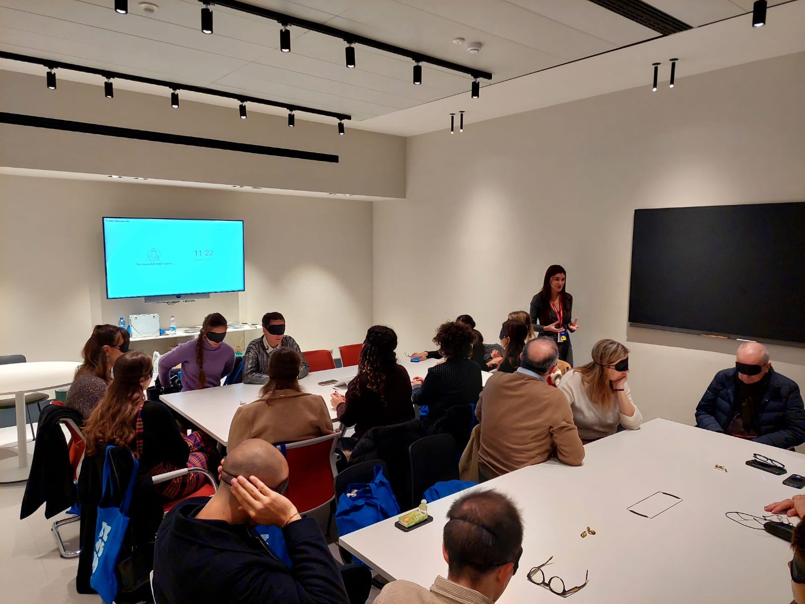 Foto del workshop di gioielli in cui le persone sono bendate e sperimentano l'arte del tatto