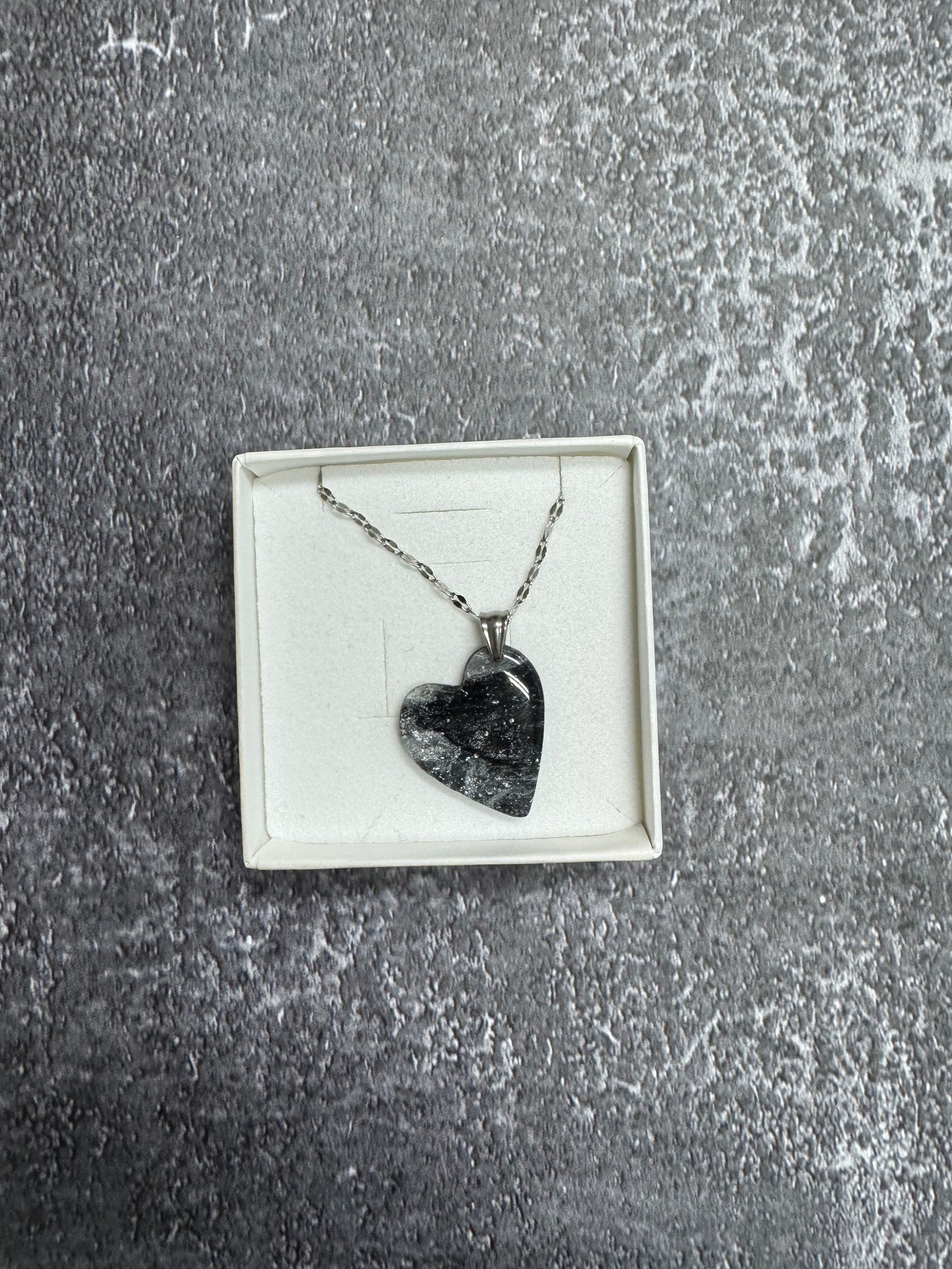 Confezione regalo aperta Myra Lab con collana pendente a forma di cuore, nera e argento, effetto marmo. 