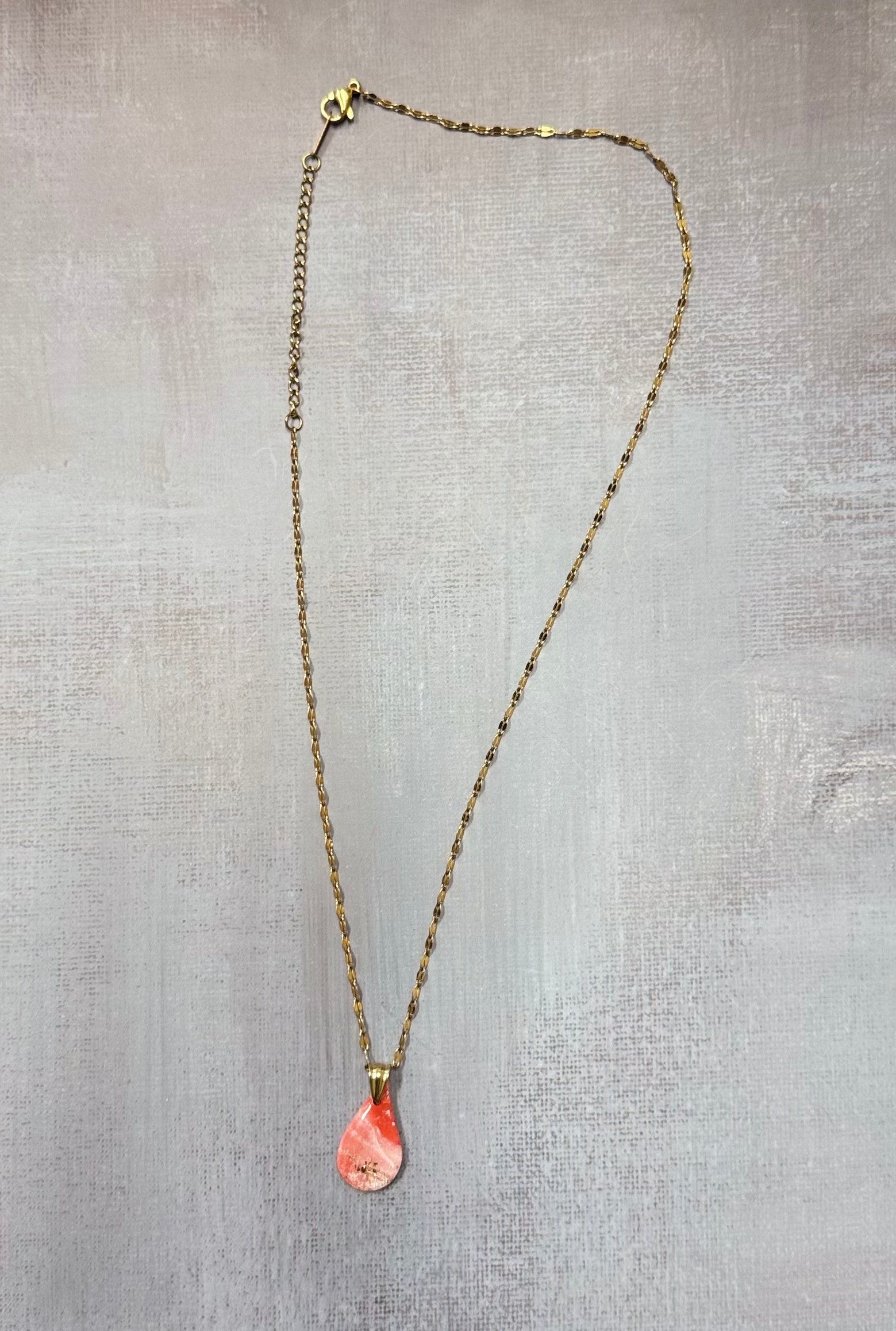 Collana con ciondolo a goccia, rosa marmorizzato in porcellana fredda con sfumature e dettagli dorati. Gioiello realizzato da artigiani ciechi e ipovedenti.