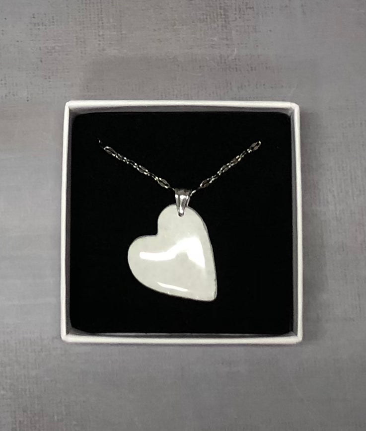 Confezione regalo aperta Myra Lab con collana pendente a cuore in porcellana fredda bianca a pois argentati. Gioiello artigianale fatto a mano da persone cieche e ipovedenti.
